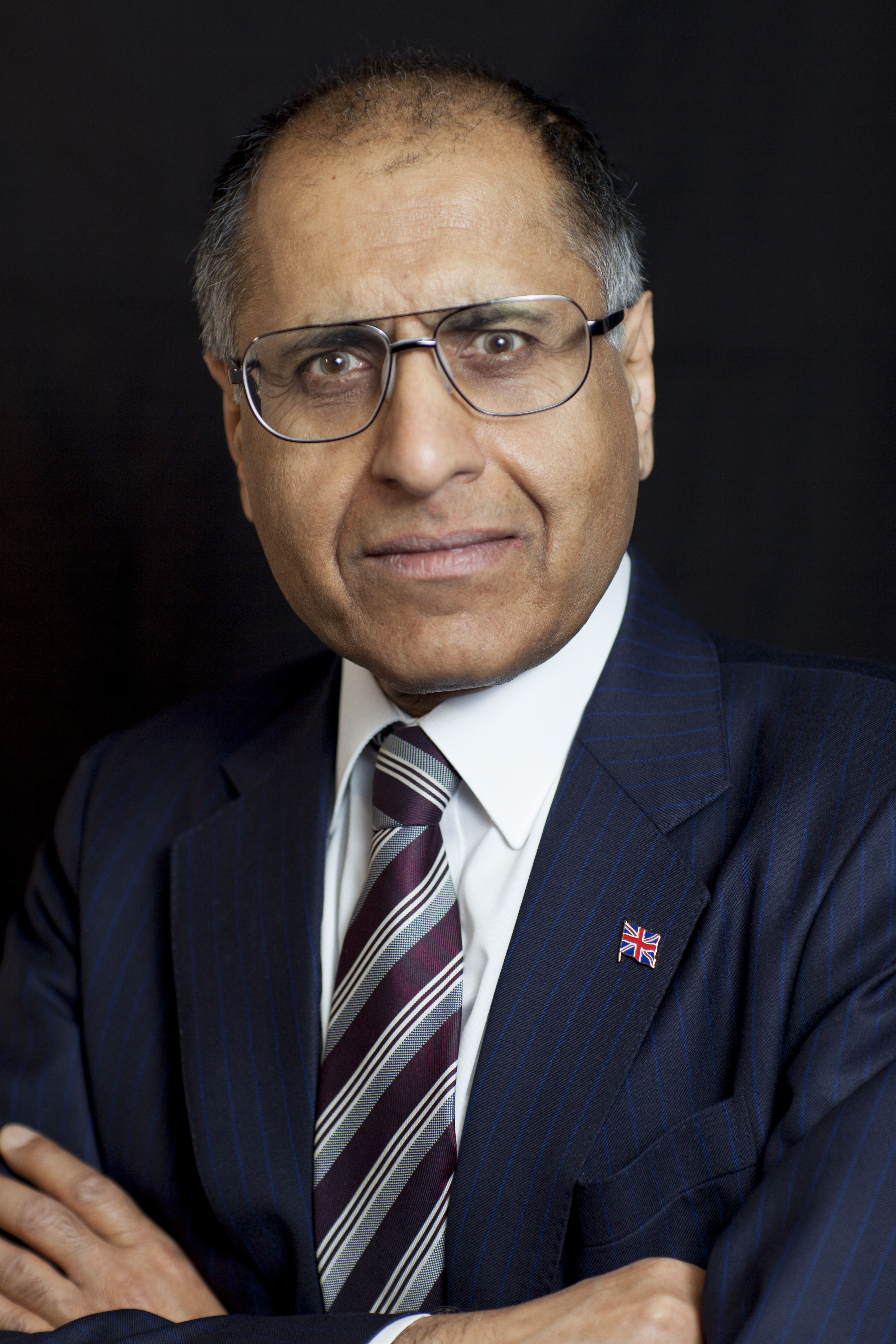 High resolution photo of Mohammed Amin wearing a jacket and tie.
